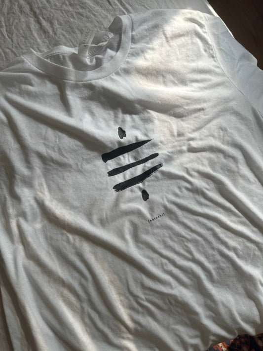 A white t-shirt with a black Satoshi Symbol on the front. The graphic is centered on the shirt. The text '(satoshi)' is printed in black below the graphic.