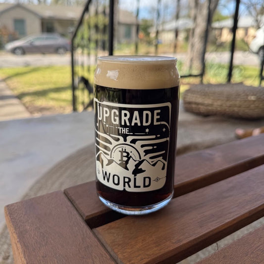 16 oz can-shaped glass filled with Guiness with white 'Upgrade the World' text and Bitcoin logo - Sovereign Goods.