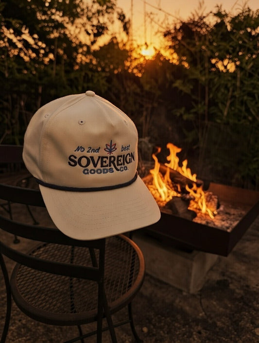 Cap with 'Sovereign Goods Co' logo by a fire pit at sunset