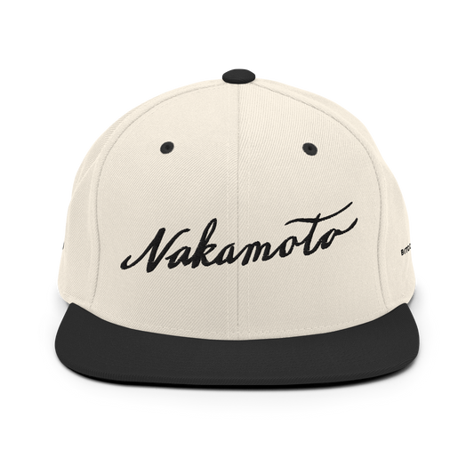Front view of a beige and black trucker hat with the word 'Nakamoto' embroidered in a script font on the front in black.