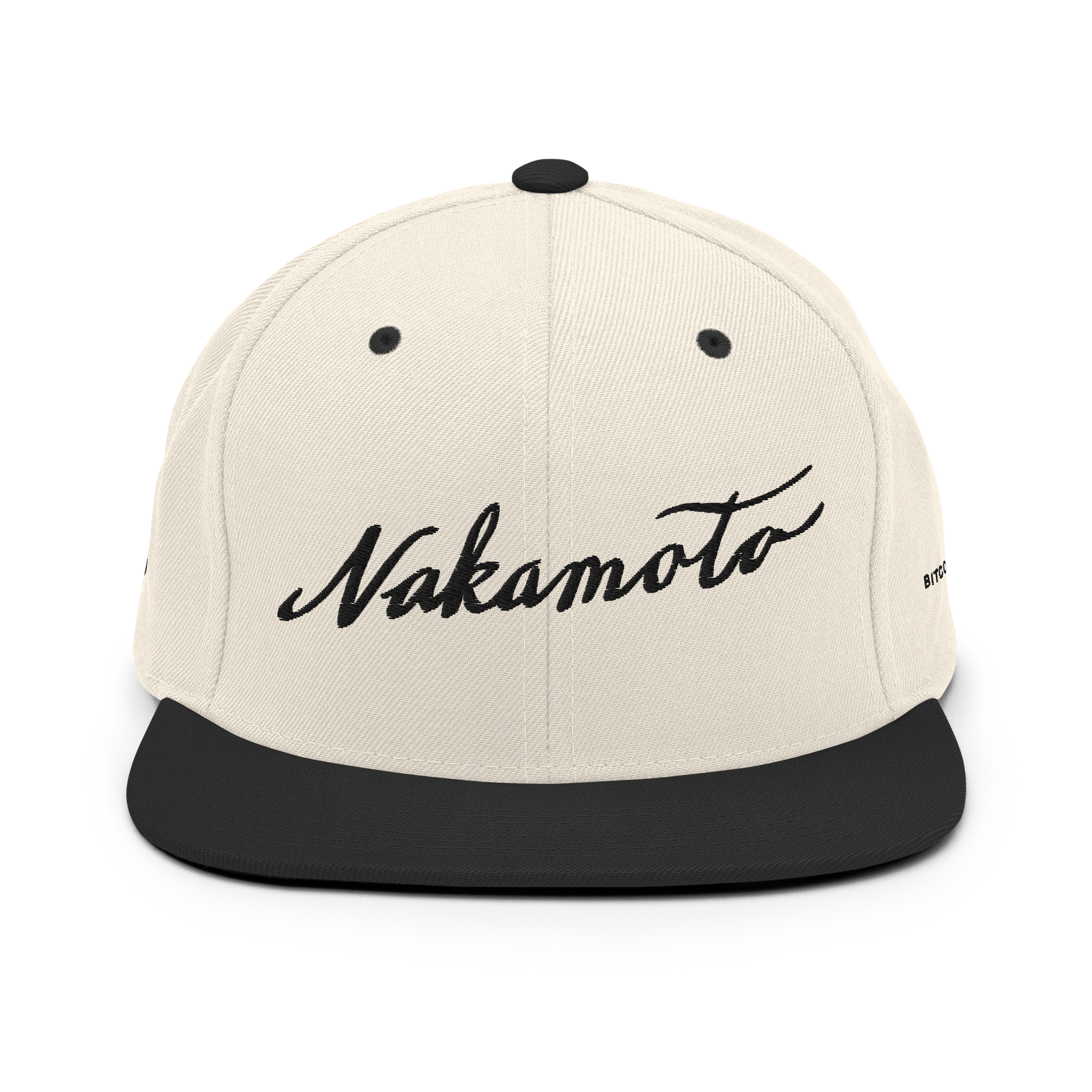 Front view of a beige and black trucker hat with the word 'Nakamoto' embroidered in a script font on the front in black.